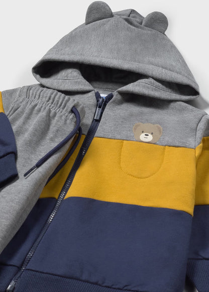 Detalle del bolsillo con un osito bordado y la capucha con orejitas de una sudadera con cremallera, marca Mayoral.