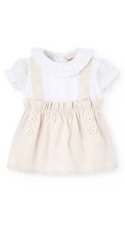 Conjunto de bebé con vestido de lino en tono beige y blusa blanca con cuello fruncido y mangas cortas.