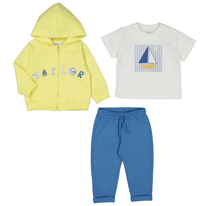 Conjunto de tres piezas para bebé con temática marinera, compuesto por una sudadera con capucha en color amarillo neón con el texto “SAILOR”, una camiseta blanca con un gráfico de velero sobre fondo de rayas y un pantalón azul con elástico en la cintura y puños en el dobladillo para mayor comodidad.