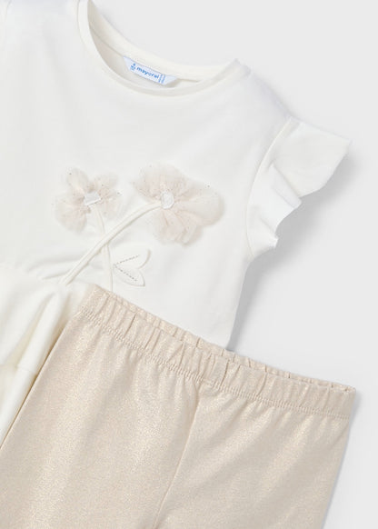 Detalle de la playera con flores bordadas en relieve y leggings brillosos del conjunto de niña de Mayoral.