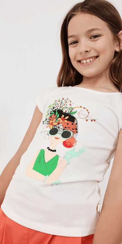 Niña modelando conjunto Boboli con playera blanca y short coral.