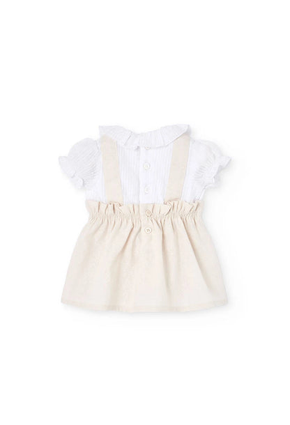 Vista trasera del conjunto para bebé con vestido de lino beige y blusa blanca con botones.