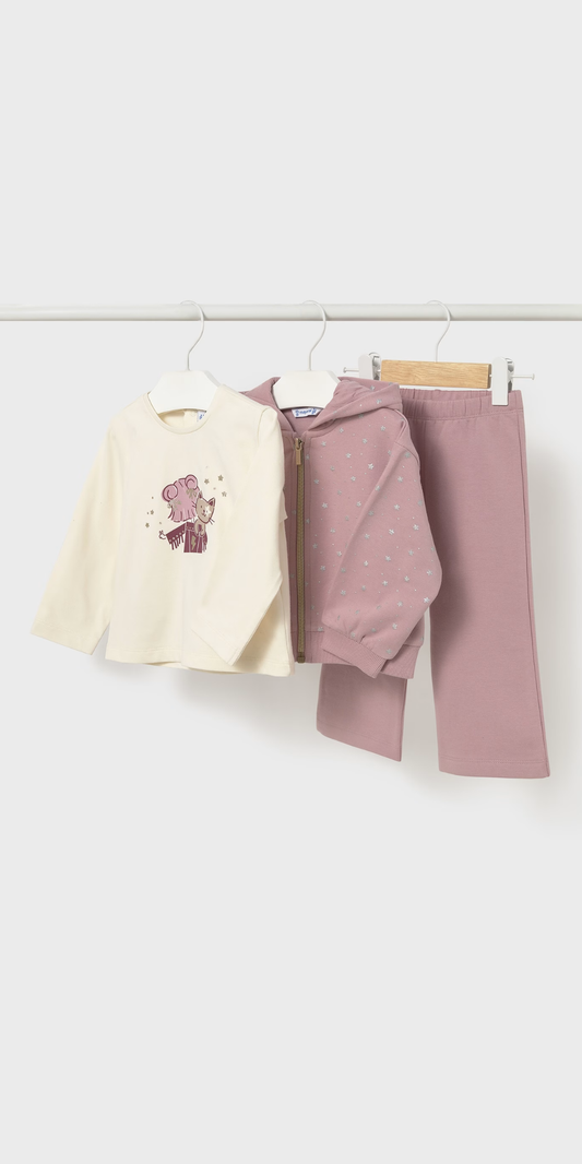 Tres piezas de ropa de niña colgadas: una playera crema con estampado de ratita, una sudadera rosa con estrellas y un pantalón rosa, marca Mayoral.