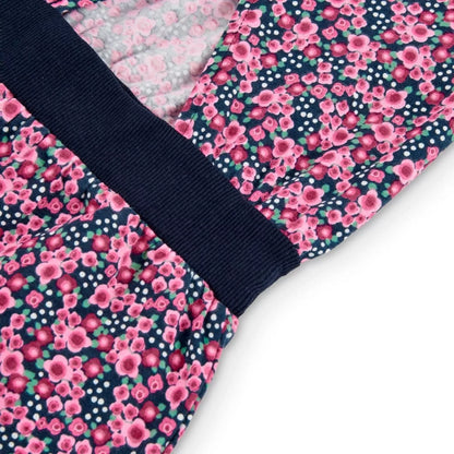 Detalle de la espalda del jumpsuit corto de Boboli con estampado floral en tonos rosas sobre fondo azul marino. Se muestra la cintura elástica en azul marino y la abertura trasera en la parte superior del diseño.