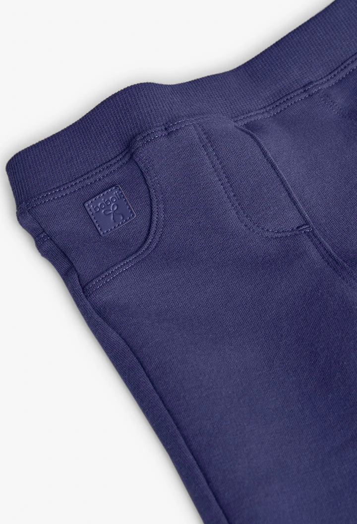 Detalle del bolsillo frontal falso y la placa de la marca en unos jeggings de felpa color morado, marca Boboli.
