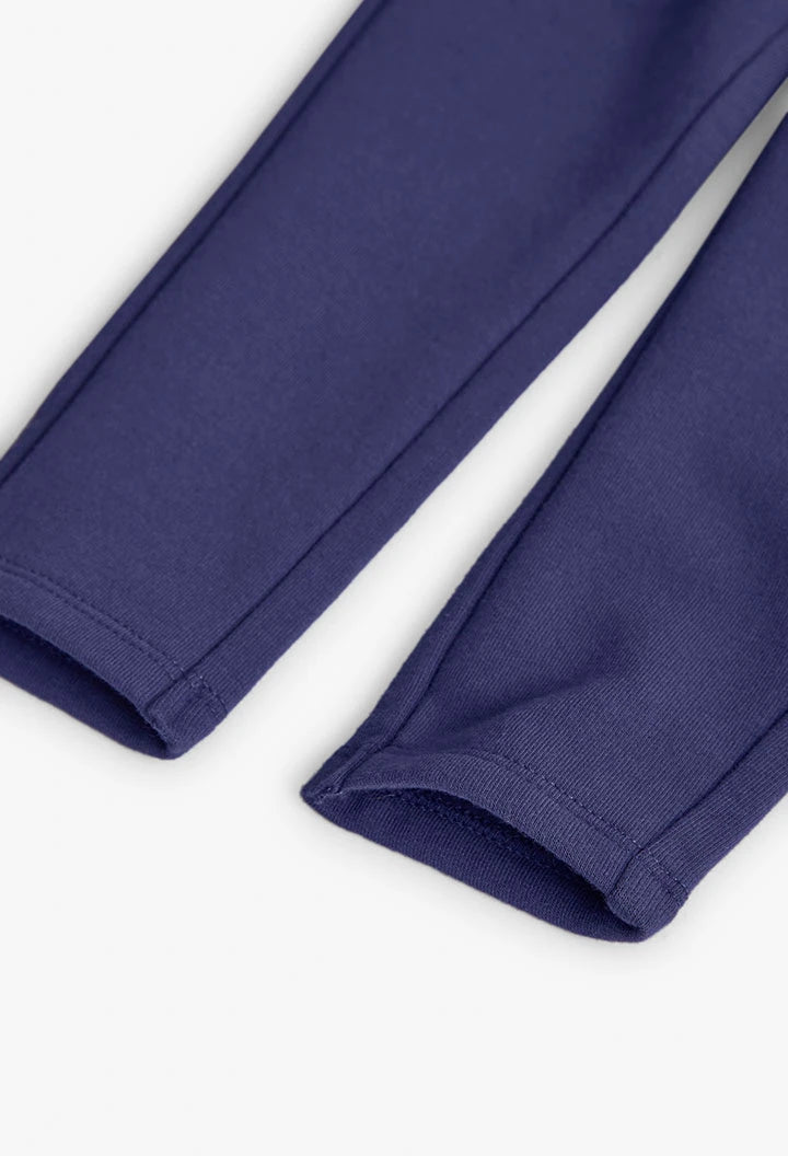 Detalle del dobladillo de unos jeggings de felpa color morado para niña.