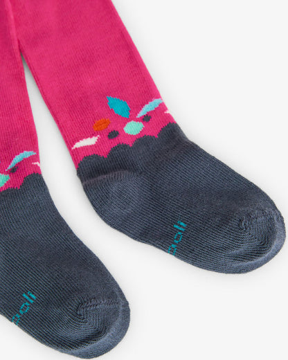 Mallas rosas de niña con puntera azul marino y detalle de hojas de colores en el tobillo.