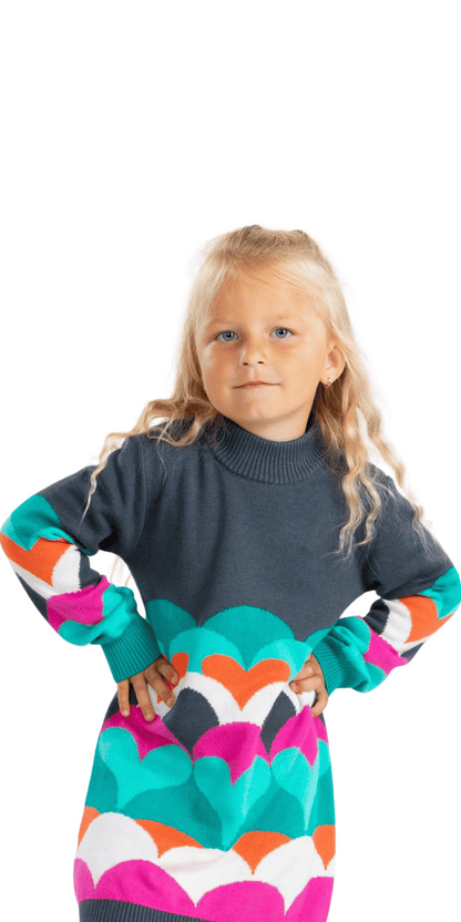 Niña usando vestido Boboli con corazones multicolor. Corte recto y cuello alto.