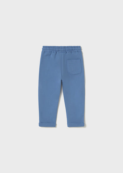 Vista trasera de un pantalón jogger azul para bebé con cintura elástica y un pequeño bolsillo en la parte posterior, diseñado para brindar comodidad y libertad de movimiento.