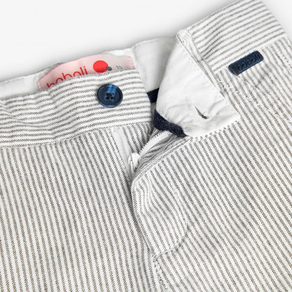 Cierre y botón del pantalón de rayas blancas y grises para niño, con etiqueta de la marca Boboli y acabado elegante.