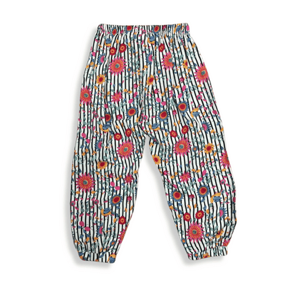 Pantalón infantil holgado con estampado de flores y rayas en tonos vibrantes, diseñado con resorte en la cintura y tobillos para mayor comodidad y estilo tropical.