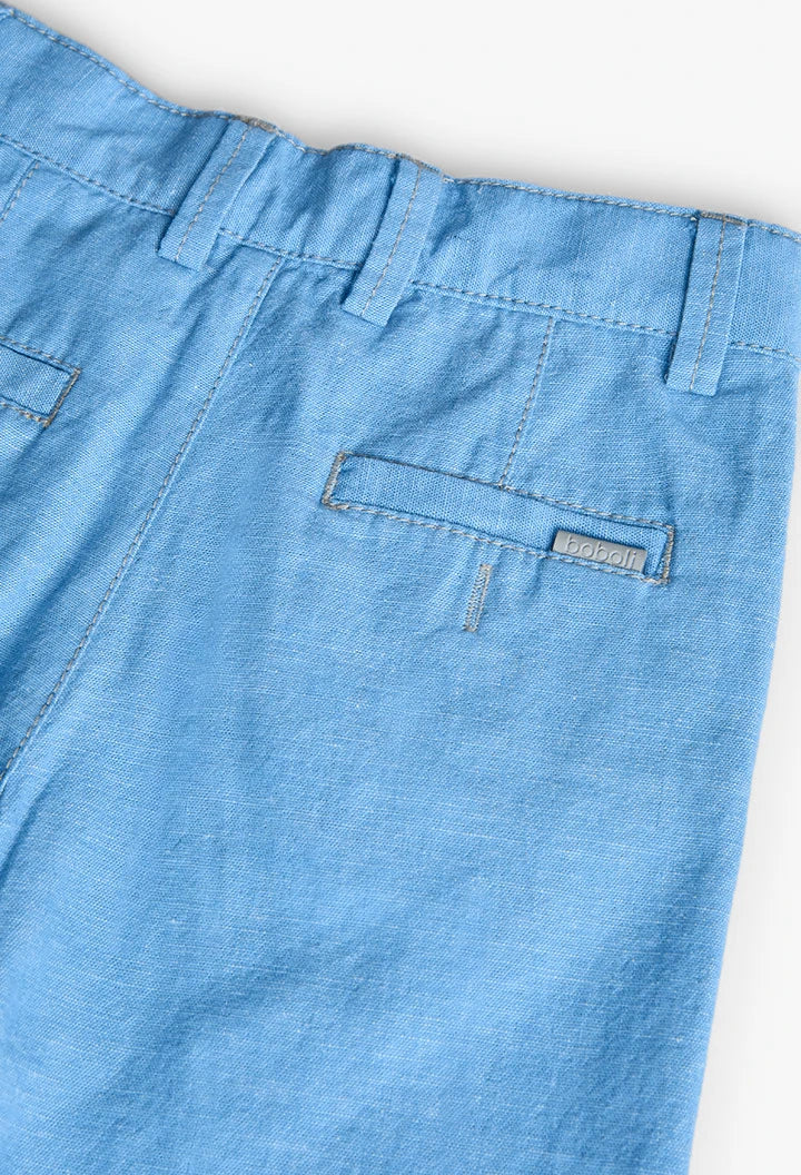 Detalle de los bolsillos traseros del pantalón corto de lino azul Boboli con etiqueta metálica de la marca.
