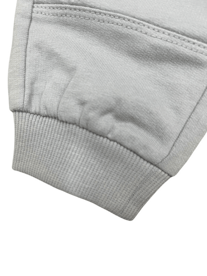 Detalle del puño acanalado del pantalón deportivo gris para niños, con costuras reforzadas y tela de algodón suave.