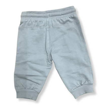 Vista trasera del pantalón deportivo gris para niños, con pretina elástica y costuras reforzadas para mayor comodidad.