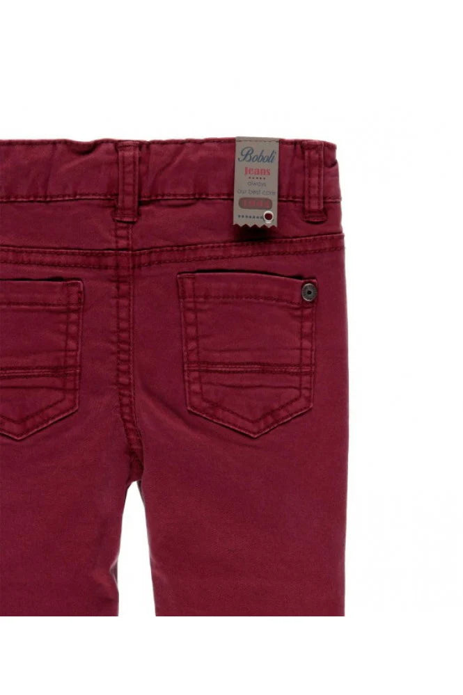 Detalle de los bolsillos traseros del pantalón burdeos con etiqueta decorativa Boboli Jeans.