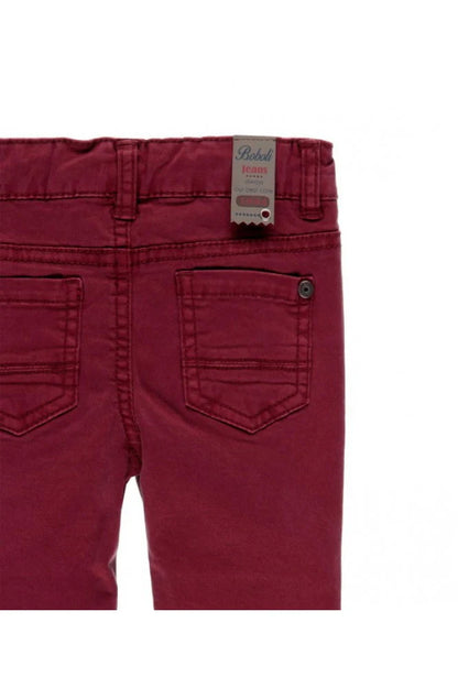 Detalle de los bolsillos traseros del pantalón burdeos con etiqueta decorativa Boboli Jeans.