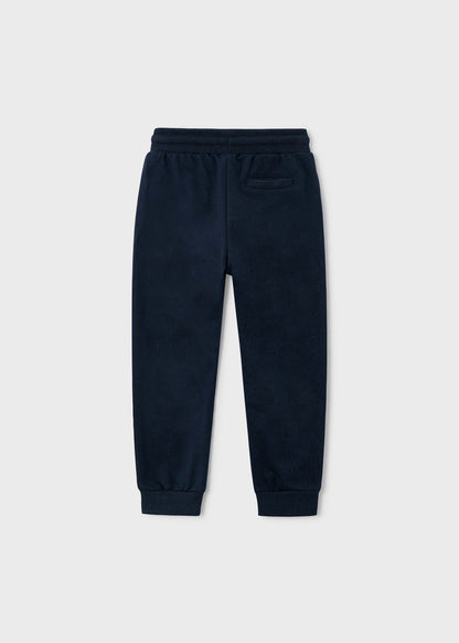 Vista trasera de un pantalón jogger de felpa color azul marino para niño.