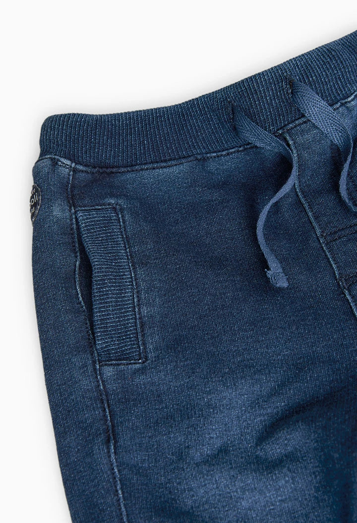 Detalle de cintura elástica con cordón y bolsillos laterales de pants azul marino tipo jogger.