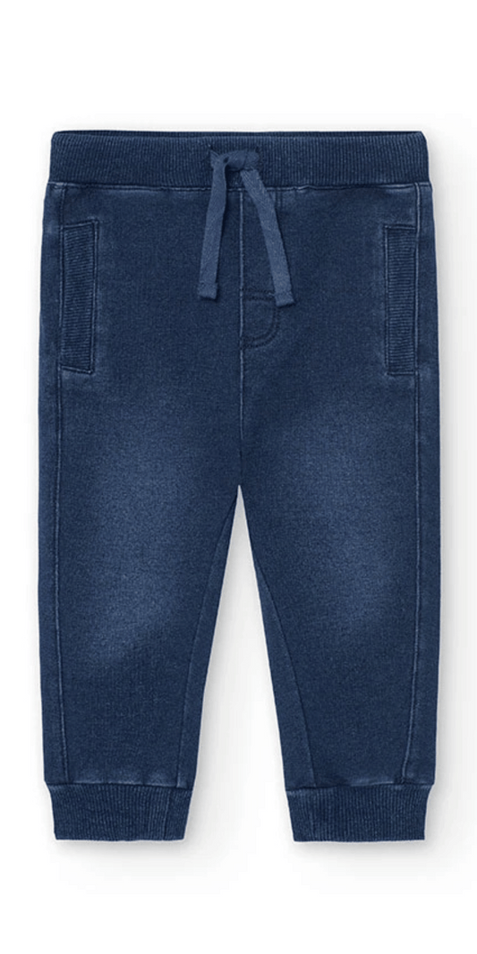 Vista frontal de pants tipo jogger azul marino para niño, con bolsillos y cintilla ajustable.