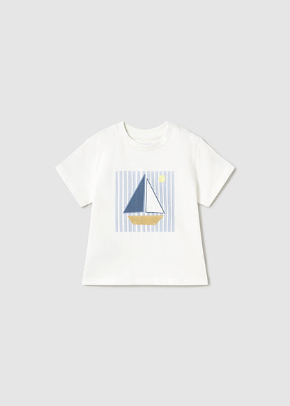 Camiseta blanca de manga corta para bebé con estampado de un barco de vela sobre un fondo de rayas azules, ideal para un look náutico y fresco.