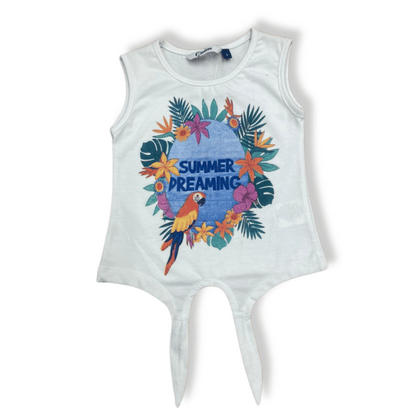 Blusa infantil sin mangas en color blanco con estampado tropical de un loro rodeado de flores y la frase “SUMMER DREAMING”. Diseño con corte asimétrico en la parte inferior para un look moderno y fresco.