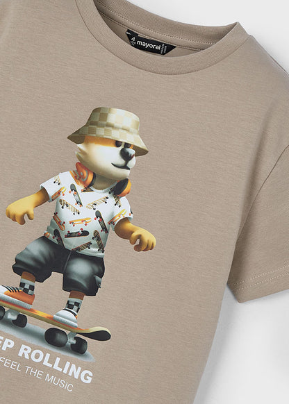 Playera beige Mayoral con estampado de perro skater con gorra y audífonos, sobre una patineta.