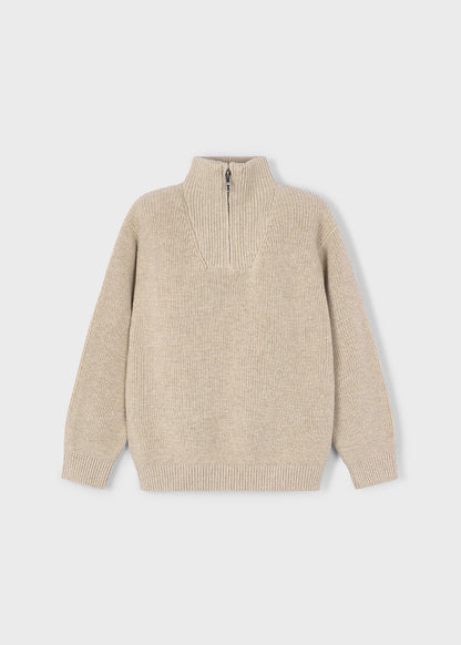 Vista frontal de un suéter de punto canalé color beige para niño, con cuello alto y medio cierre de cremallera, marca Mayoral.