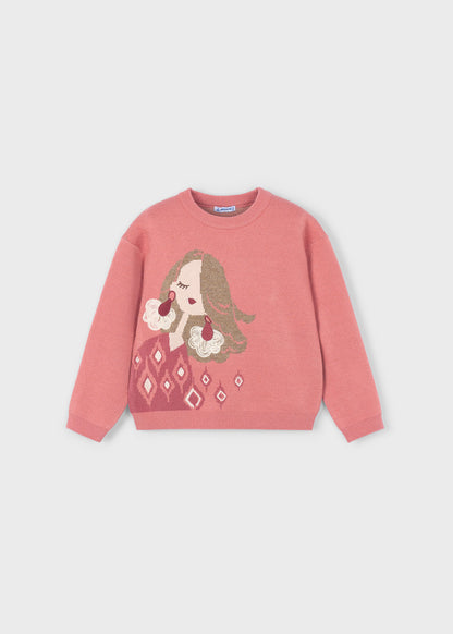 Vista frontal de un suéter de punto color rosa para niña, con el dibujo de una muñeca con pelo brillante y detalles de rombos, marca Mayoral.