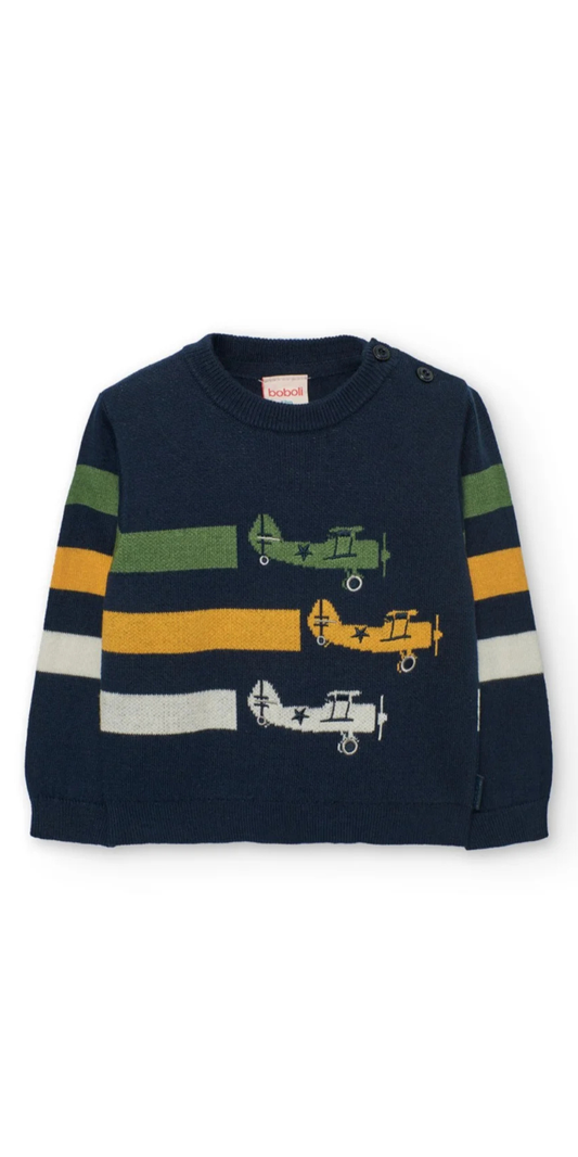 Vista frontal de un suéter de punto azul marino para niño con un diseño de aviones de época y rayas de colores en las mangas, marca Boboli.