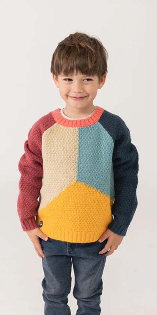 Niño sonriendo con un suéter de punto texturizado con un diseño geométrico de bloques de colores, marca Boboli.