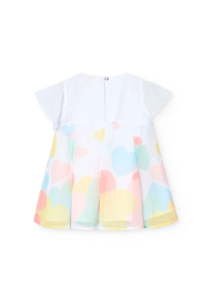 Vista trasera de un vestido blanco con estampado de corazones de colores pastel, manga corta y cierre con botón en la espalda.
