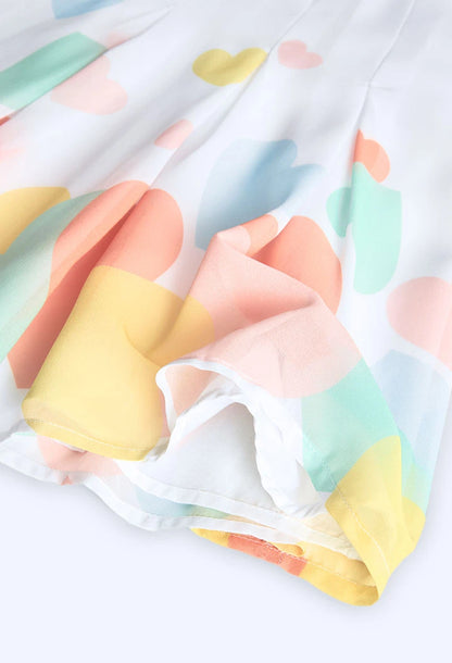 Vestido blanco de manga corta con estampado de corazones en colores pastel, ideal para verano.