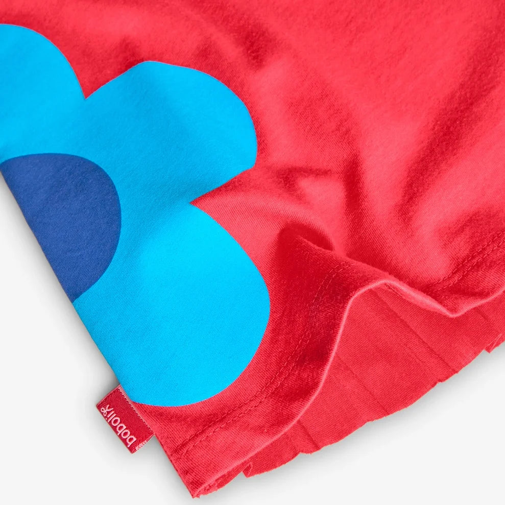 Primer plano del dobladillo del vestido Boboli con flor azul estampada.