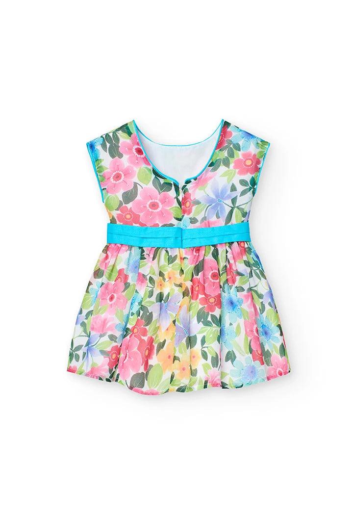 Vista trasera de un vestido de gasa para niña con estampado de flores en tonos vibrantes y lazo azul en la cintura.
