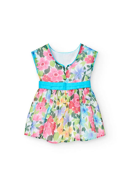 Vista trasera de un vestido de gasa para niña con estampado de flores en tonos vibrantes y lazo azul en la cintura.
