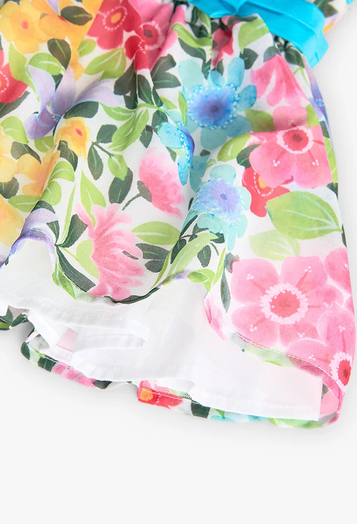 Detalle inferior de un vestido de gasa con estampado floral, mostrando la suavidad y caída del tejido.