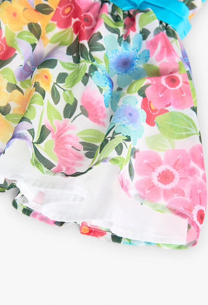 Detalle inferior de un vestido de gasa con estampado floral, mostrando la suavidad y caída del tejido.