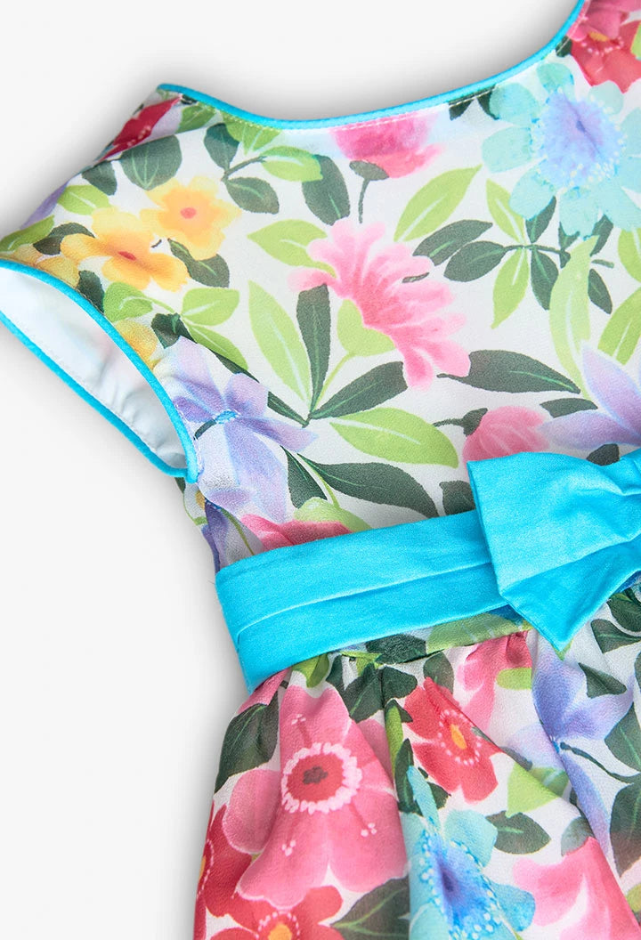 Vista detallada del vestido de gasa para niña con estampado floral y lazo azul en la cintura.