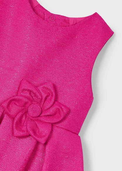 Detalle del tejido y diseño del vestido magenta fiusha de Mayoral, con pliegues delicados y acabado brillante.
