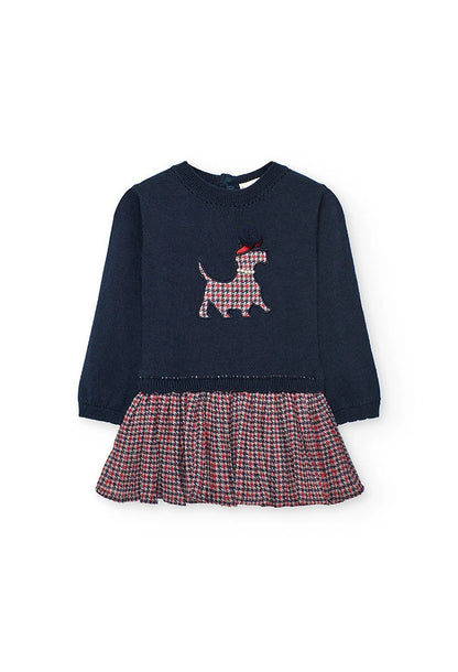 Vista frontal de un vestido para niña con cuerpo de punto azul marino y falda plisada con estampado de pata de gallo, marca Boboli.
